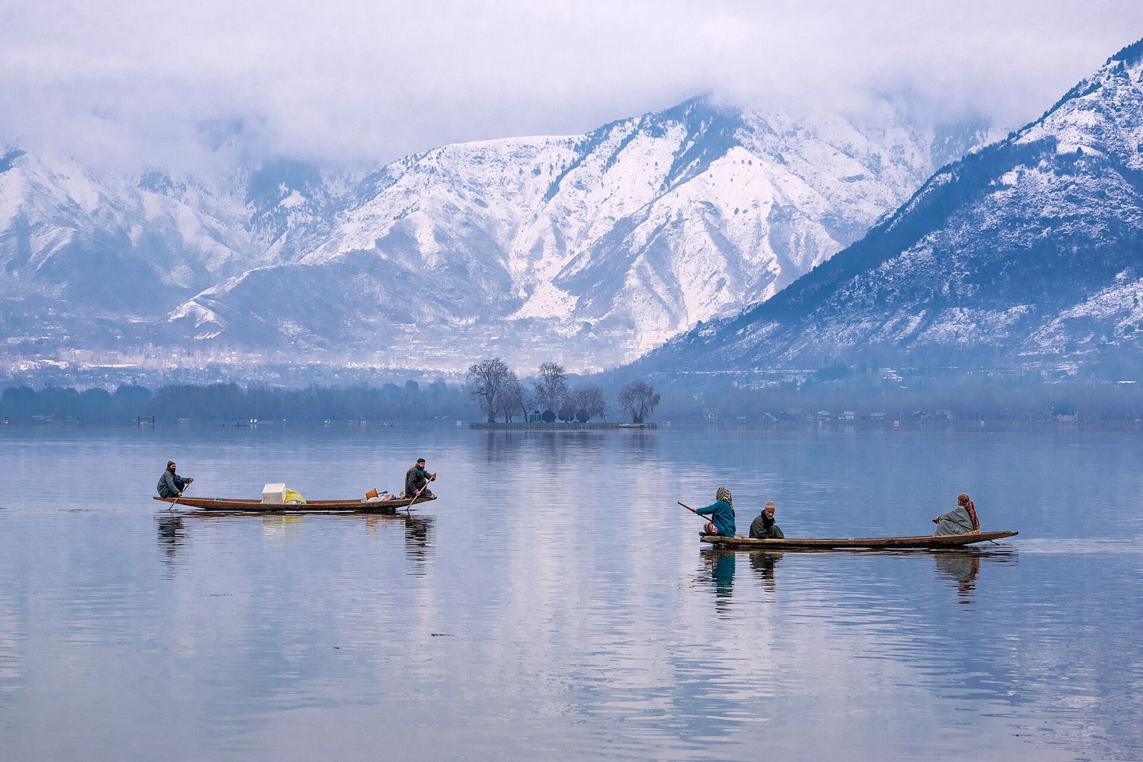 Shikaras on Dal Lake with snow-covered mountains behind Srinagar